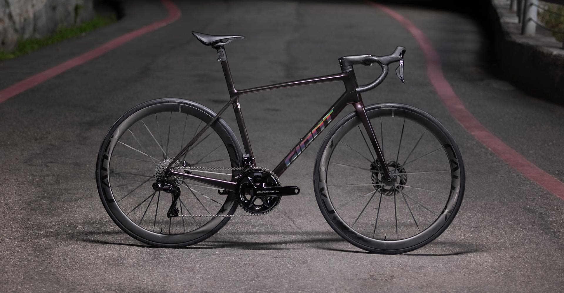 Vélo de route Giant Advanced SL Disc violet iridescent, groupe Shimano Dura-Ace et roues Cadex sur asphalte.