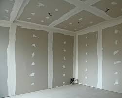 Pièce en construction. Murs et plafond en placoplâtre avec joints d'enduit blancs et points de rebouchage sur cloisons sèches.